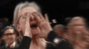 Meryl Streep cupping her hands and shouting.